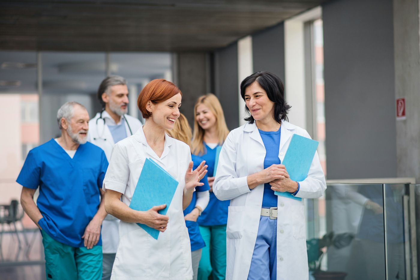 Team aus Medizin und Pflege im Gespräch auf einem Klinikflur