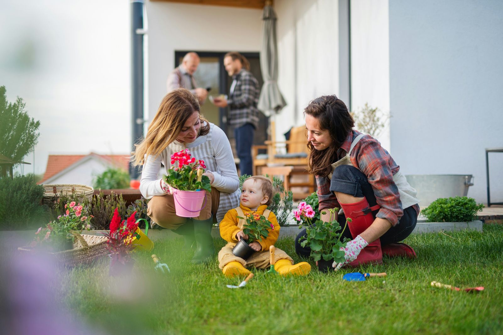 Familie bei der Gartenarbeit vor dem eigenen Haus